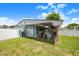 Backyard with storage building, carport, small golf cart, and room for landscaping at 114 Belmont Dr, Winter Haven, FL 33884