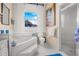 Well-lit bathroom featuring a soaking tub, separate shower, and elegant white tile at 114 Belmont Dr, Winter Haven, FL 33884