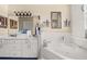Bright bathroom showcasing double sinks, a soaking tub, and a large decorative mirror at 114 Belmont Dr, Winter Haven, FL 33884
