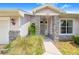 Close up of front porch with stone columns, hanging light fixture, and well-manicured landscaping at 114 Belmont Dr, Winter Haven, FL 33884