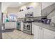Well-equipped kitchen featuring white cabinets, stainless steel appliances, and tile flooring at 114 Belmont Dr, Winter Haven, FL 33884