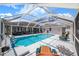 Private screened-in pool oasis featuring a covered patio, lounge chairs, and serene atmosphere at 114 Belmont Dr, Winter Haven, FL 33884