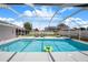 Screened-in pool with sparkling blue water, surrounded by ample patio space and seating at 114 Belmont Dr, Winter Haven, FL 33884