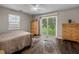 Cozy bedroom with warm hardwood floors, sliding doors to a patio, and a ceiling fan at 1256 Center St, Lake Wales, FL 33859