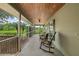 View of the long and screened in porch with chairs and a ceiling fan providing a relaxing outdoor space at 1256 Center St, Lake Wales, FL 33859