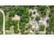 Aerial view of a home on a spacious lot, surrounded by mature trees and a winding sand road at 1273 Scrub Jay Trl, Frostproof, FL 33843