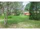 Expansive backyard with lush lawn, trees and a view of the home, great for outdoor activities and relaxation at 1273 Scrub Jay Trl, Frostproof, FL 33843