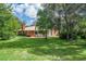 Picturesque backyard with a well-manicured lawn, mature trees, and a seating area for relaxation at 1273 Scrub Jay Trl, Frostproof, FL 33843