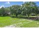 Spacious backyard featuring lush green grass, mature trees, and a wooden fence for privacy at 1273 Scrub Jay Trl, Frostproof, FL 33843