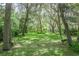Lush backyard shaded by mature trees offers a tranquil retreat with benches, perfect for enjoying nature at 1273 Scrub Jay Trl, Frostproof, FL 33843