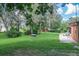 A spacious backyard with a lush lawn, trees, a fire pit, and a patio is ideal for outdoor activities at 1273 Scrub Jay Trl, Frostproof, FL 33843