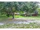 Spacious backyard with lush lawn, mature trees, and a gazebo-style structure, creating a peaceful outdoor retreat at 1273 Scrub Jay Trl, Frostproof, FL 33843