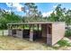 Exterior of a horse barn with three stalls, featuring sturdy wooden construction and a metal roof, nestled in a rural setting at 1273 Scrub Jay Trl, Frostproof, FL 33843
