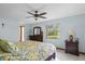 Bright bedroom with a ceiling fan, a large window, and wood furniture at 1273 Scrub Jay Trl, Frostproof, FL 33843