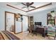 This is a primary bedroom with a ceiling fan, an office area, and an attached bathroom at 1273 Scrub Jay Trl, Frostproof, FL 33843