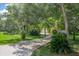 A long winding driveway leads to a beautiful home surrounded by mature trees and lush landscaping at 1273 Scrub Jay Trl, Frostproof, FL 33843