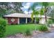 A charming home exterior with stone accents, a metal roof, and lush landscaping creates an inviting curb appeal at 1273 Scrub Jay Trl, Frostproof, FL 33843