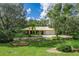 Charming home with metal roof, stone accents, lush landscaping, and inviting curb appeal, creating a serene setting at 1273 Scrub Jay Trl, Frostproof, FL 33843