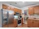 Well-equipped kitchen features stainless steel appliances, ample counter space, and wood cabinets, perfect for cooking and gathering at 1273 Scrub Jay Trl, Frostproof, FL 33843