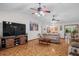 Expansive living room with three ceiling fans, tv and seamless flow into kitchen and dining areas, ideal for entertaining at 1273 Scrub Jay Trl, Frostproof, FL 33843