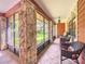 Inviting screened-in porch with stone pillars, tile flooring, and comfortable wicker seating at 1273 Scrub Jay Trl, Frostproof, FL 33843