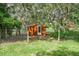 Small red shed with fencing, nestled among trees, offering a quaint storage space in a serene, natural setting at 1273 Scrub Jay Trl, Frostproof, FL 33843