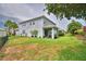 Exterior view of a home featuring a spacious backyard with lush green grass and palm trees at 1433 Bunker Dr, Davenport, FL 33896
