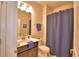 Well-lit bathroom features a dark vanity, toilet and shower with blue accents at 1433 Bunker Dr, Davenport, FL 33896