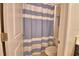 Small bathroom with toilet inside a room with a blue and white striped curtain at 1433 Bunker Dr, Davenport, FL 33896