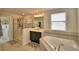 Bright bathroom featuring a shower, bathtub, black vanity, and a large window at 1433 Bunker Dr, Davenport, FL 33896