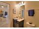 Cozy bathroom with dark vanity, sink and toilet enhanced with nautical wall art at 1433 Bunker Dr, Davenport, FL 33896