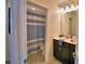 Half bathroom featuring a vanity with dark cabinets, a white countertop and a large mirror at 1433 Bunker Dr, Davenport, FL 33896