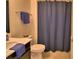 The bathroom features a toilet, sink, and shower with a stylish blue shower curtain at 1433 Bunker Dr, Davenport, FL 33896