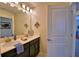 Bright bathroom featuring a vanity with double sinks, dark wood cabinets, and a large mirror at 1433 Bunker Dr, Davenport, FL 33896