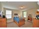 Neutral bedroom featuring a bed with built-in storage, carpeted floors, and lots of light from two windows at 1433 Bunker Dr, Davenport, FL 33896