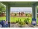 Inviting covered patio offers comfortable seating, potted greenery, and scenic views of the lush, well-maintained backyard at 1433 Bunker Dr, Davenport, FL 33896