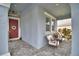 Inviting front porch featuring a cozy seating area and a charming red door with wreath at 1433 Bunker Dr, Davenport, FL 33896