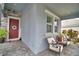 Front porch featuring cozy seating area, welcome sign, and red door with wreath at 1433 Bunker Dr, Davenport, FL 33896