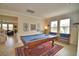 Open concept game room provides an area to play pool, relax on a bench, or transition to other areas of the home at 1433 Bunker Dr, Davenport, FL 33896