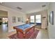This game room features a pool table, bench seating, beige tile floors and neutral colored walls for a comfortable space at 1433 Bunker Dr, Davenport, FL 33896
