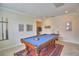 Game room features a pool table with blue felt, beige tile flooring, and neutral colored walls for a soothing space at 1433 Bunker Dr, Davenport, FL 33896