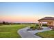 Picturesque golf course view at sunset, featuring manicured greens and a walking path at 1433 Bunker Dr, Davenport, FL 33896