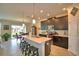 This kitchen includes a dining area, features an island with seating, dark cabinets, and light tile flooring at 1433 Bunker Dr, Davenport, FL 33896