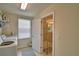 Bright laundry room with shelving, washer, and access to a bathroom with a glass-enclosed shower at 1433 Bunker Dr, Davenport, FL 33896