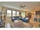 Open concept living room area boasts a blue sectional and neutral ottoman adjacent to the dining area and kitchen at 1433 Bunker Dr, Davenport, FL 33896