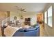 This living room boasts a plush blue sectional, neutral ottoman and light tile flooring for a cozy gathering space at 1433 Bunker Dr, Davenport, FL 33896