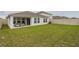 A spacious, grassy backyard features a covered patio, white fence, and tidy landscaping at 1719 Durden Dr, Winter Haven, FL 33880