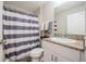 Well-lit bathroom with granite countertops, a striped shower curtain, and modern fixtures for a clean and fresh feel at 1719 Durden Dr, Winter Haven, FL 33880