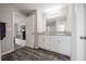 Bathroom features double sink with granite counters, white cabinets, and door to the bedroom at 1719 Durden Dr, Winter Haven, FL 33880
