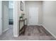 Bright entryway with wood-look floors, leading to a bedroom and featuring a stylish console table with decor at 1719 Durden Dr, Winter Haven, FL 33880
